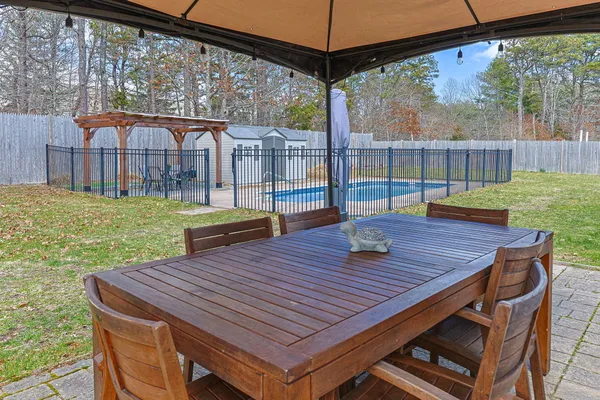 a view of a patio with a table chairs and a backyard
