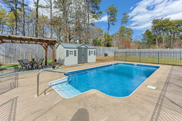 swimming pool view with two chairs and a table
