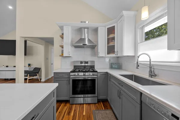 a kitchen with stainless steel appliances a stove a sink and a microwave