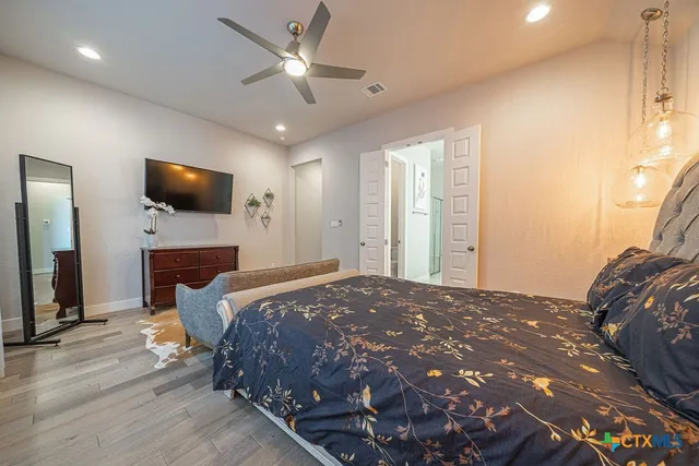 a bedroom with a bed and a flat screen tv