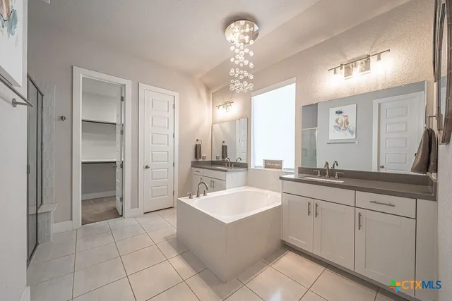 a large bathroom with a double vanity sink a mirror and a bathtub