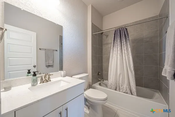 a bathroom with a sink mirror vanity and toilet