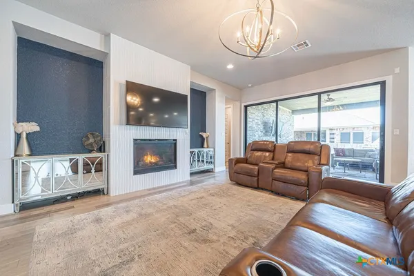 a living room with furniture a flat screen tv and a fireplace
