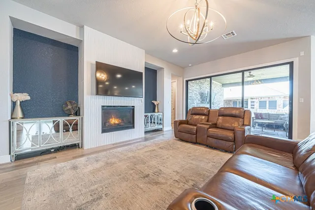 a living room with furniture a flat screen tv and a fireplace
