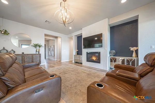 a living room with furniture a flat screen tv and a fireplace