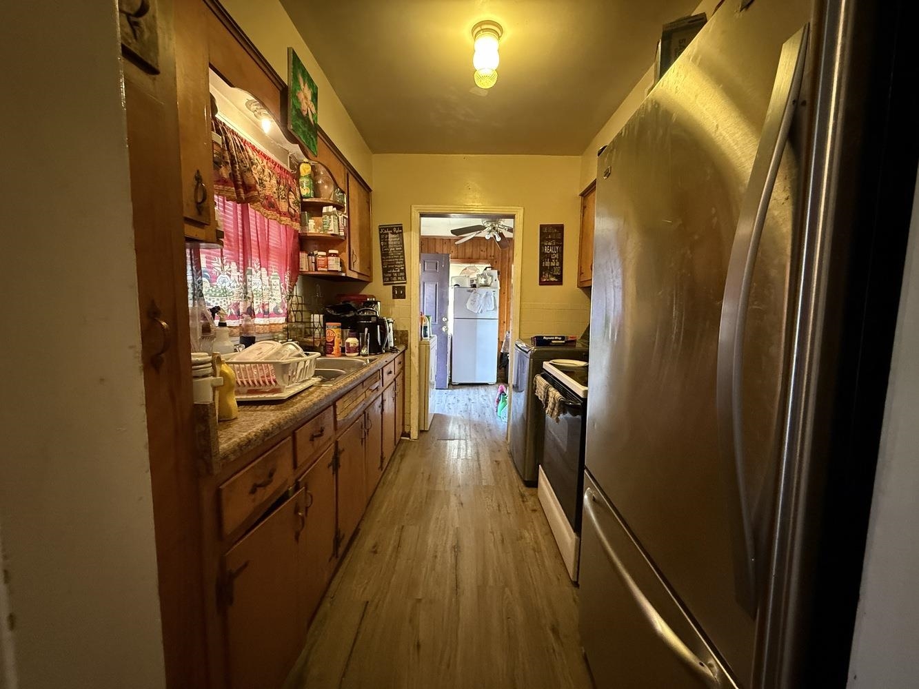 1309 Semmes Street Memphis, TN 38111 - Photo 7 of 24 Kitchen with freestanding refrigerator, light wood-style floors, range with electric stovetop, and brown cabinets