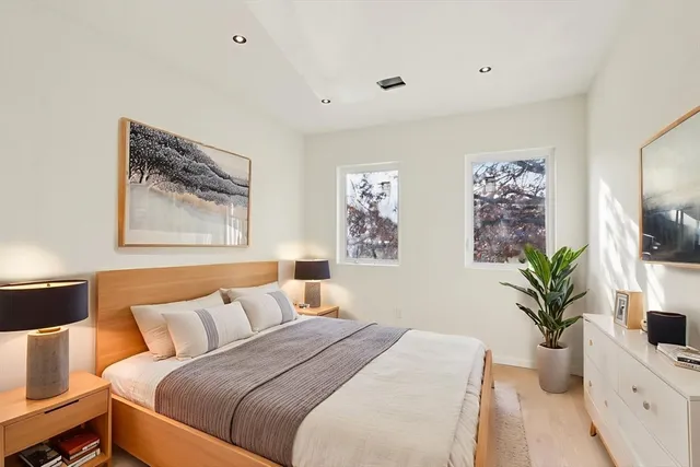 a bedroom with a large bed and a potted plant