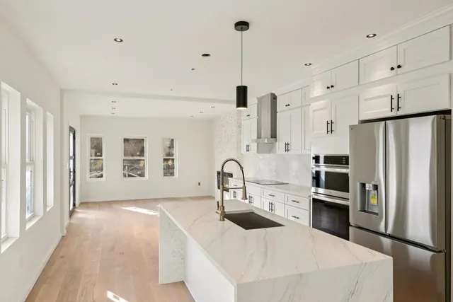 a kitchen with stainless steel appliances a refrigerator sink and cabinets