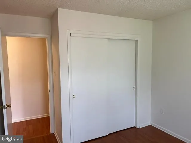 a view of a big room with wooden floor and windows