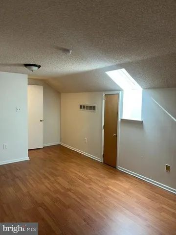 a view of a room with gym equipment and wooden floor