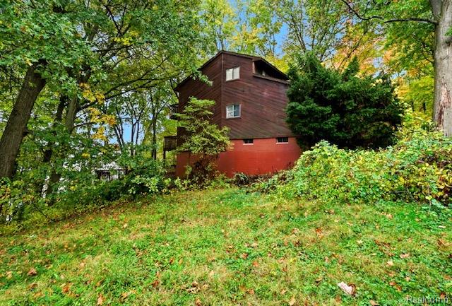 8890 Tipsico Lake Road Holly, MI 48442 - Photo 5 of 20 Wood-sided exterior with a red foundation