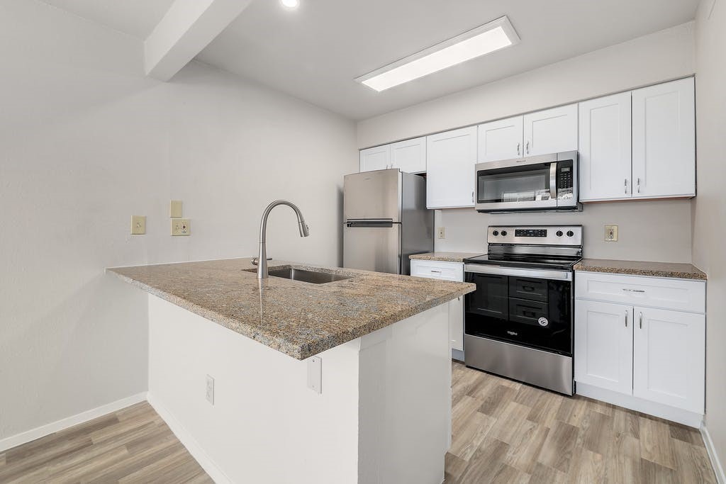 6910 Hart Lane, Unit 907 Austin, TX 78731 - Photo 13 of 28 a kitchen with stainless steel appliances granite countertop a kitchen island a stove a sink a microwave and cabinets