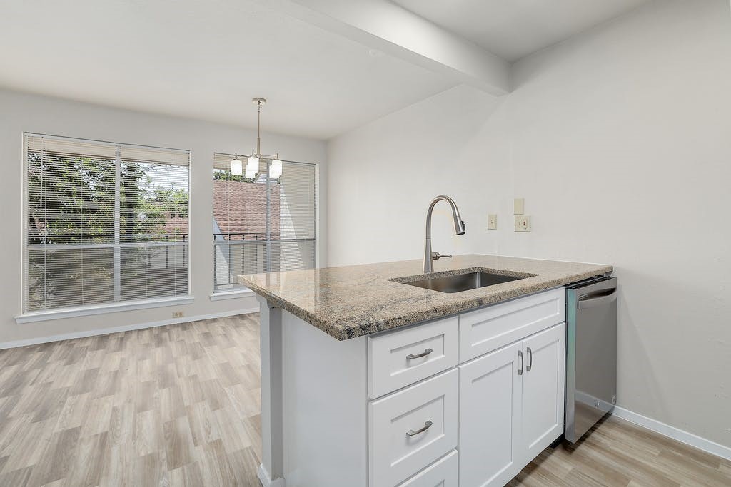 6910 Hart Lane, Unit 907 Austin, TX 78731 - Photo 14 of 28 a kitchen with granite countertop a sink and cabinets