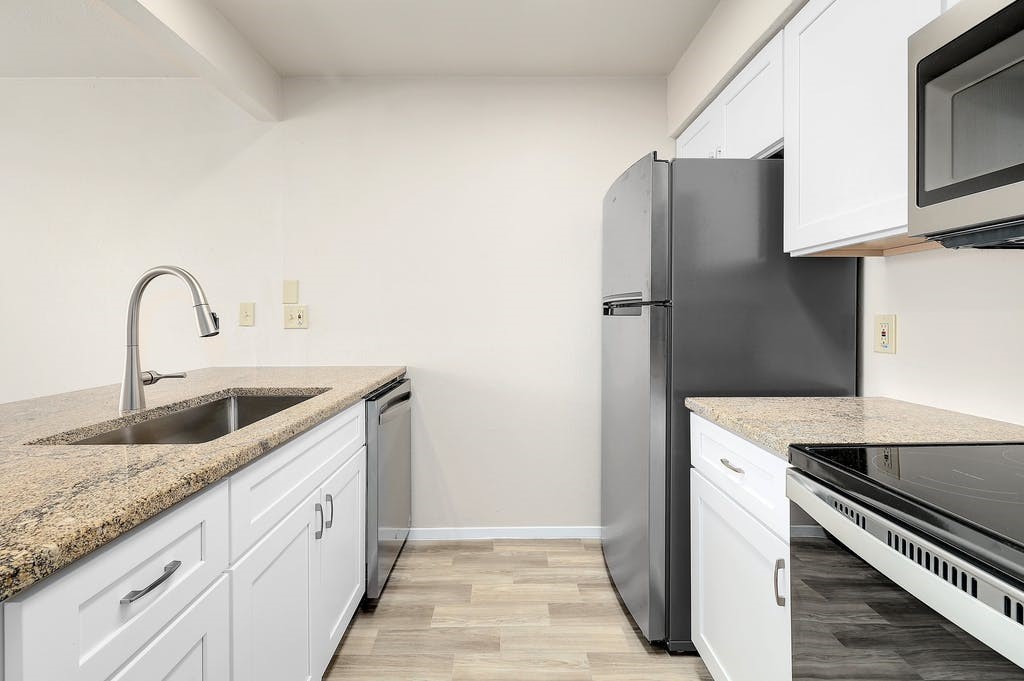 6910 Hart Lane, Unit 907 Austin, TX 78731 - Photo 15 of 28 a kitchen with stainless steel appliances granite countertop a refrigerator and a sink