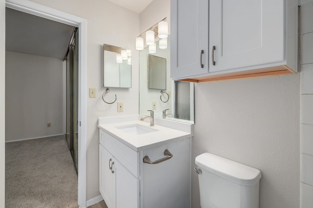 6910 Hart Lane, Unit 907 Austin, TX 78731 - Photo 20 of 28 a bathroom with a sink toilet and mirror
