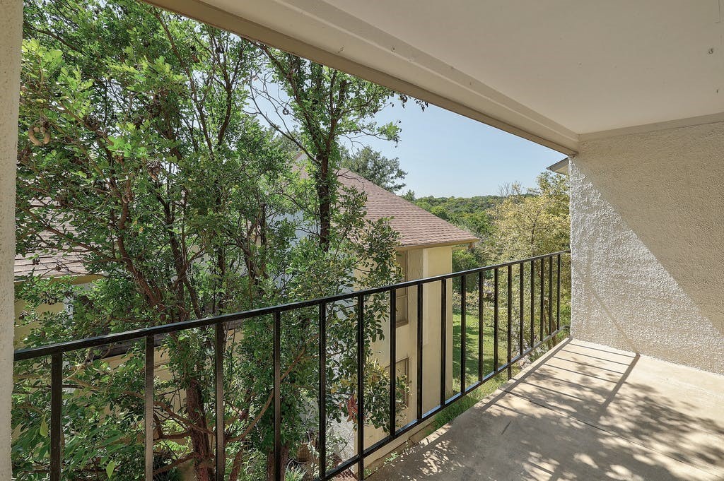 6910 Hart Lane, Unit 907 Austin, TX 78731 - Photo 25 of 28 a view of a balcony with wooden floor and fence