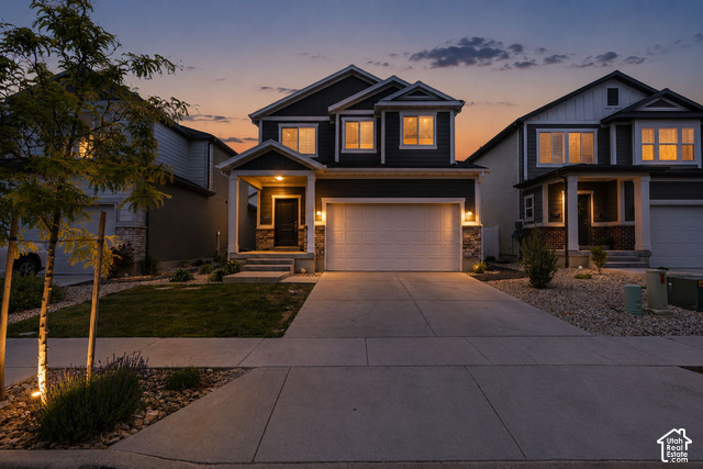 7723 Conger Road Magna, UT 84044 - Photo 2 of 24 Two-story residence featuring a stone and siding exterior, an attached two-car garage, and a covered front porch