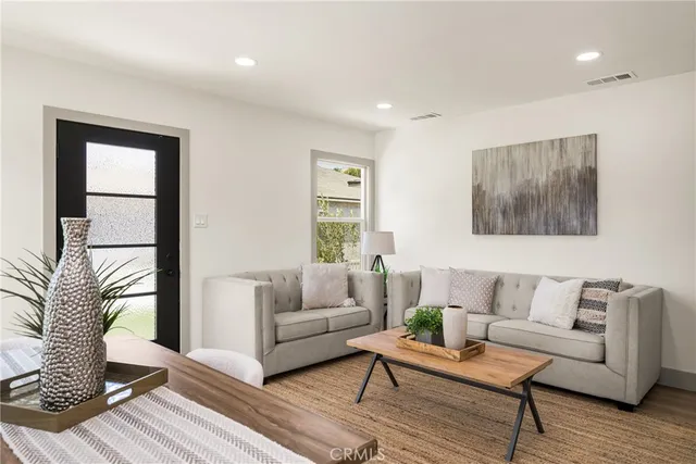 a living room with furniture potted plant and a large window