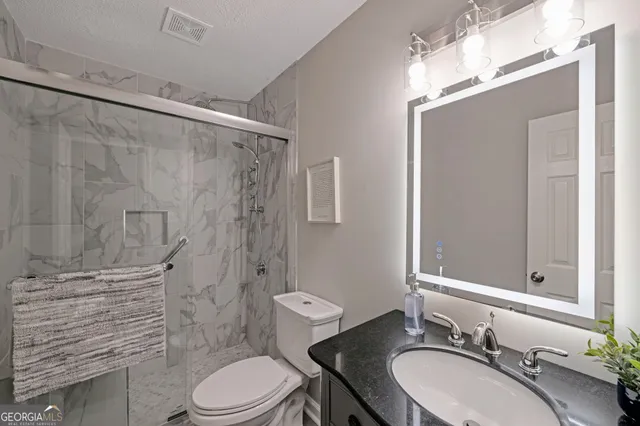 a bedroom with a large bed and a ceiling fan