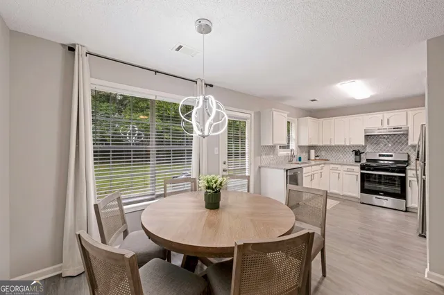 a kitchen with a refrigerator and white cabinets
