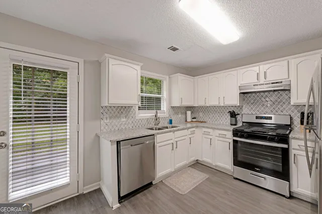 a kitchen with a refrigerator stove and sink