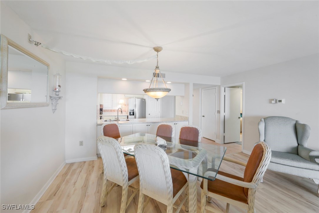 15010 Punta Rassa Road, Unit 108 Fort Myers, FL 33908 - Photo 12 of 30 a view of a dining room with furniture and wooden floor