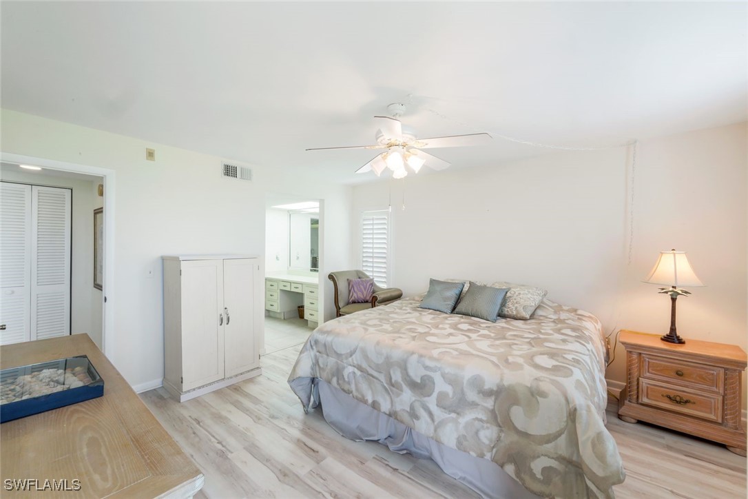 15010 Punta Rassa Road, Unit 108 Fort Myers, FL 33908 - Photo 13 of 30 a bedroom with a bed and a chandelier