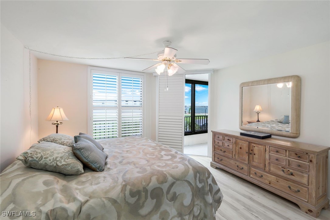 15010 Punta Rassa Road, Unit 108 Fort Myers, FL 33908 - Photo 15 of 30 a bedroom with a large bed and a chandelier