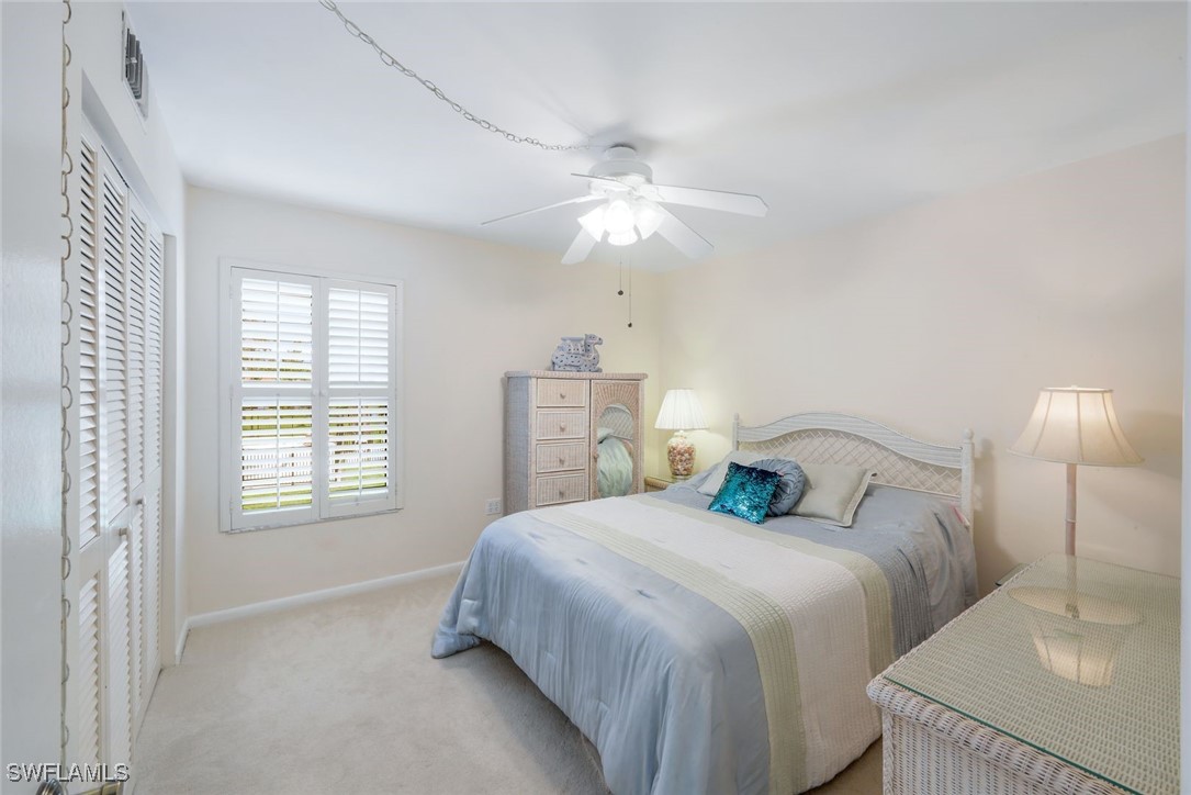 15010 Punta Rassa Road, Unit 108 Fort Myers, FL 33908 - Photo 18 of 30 a bedroom with a bed and a chandelier