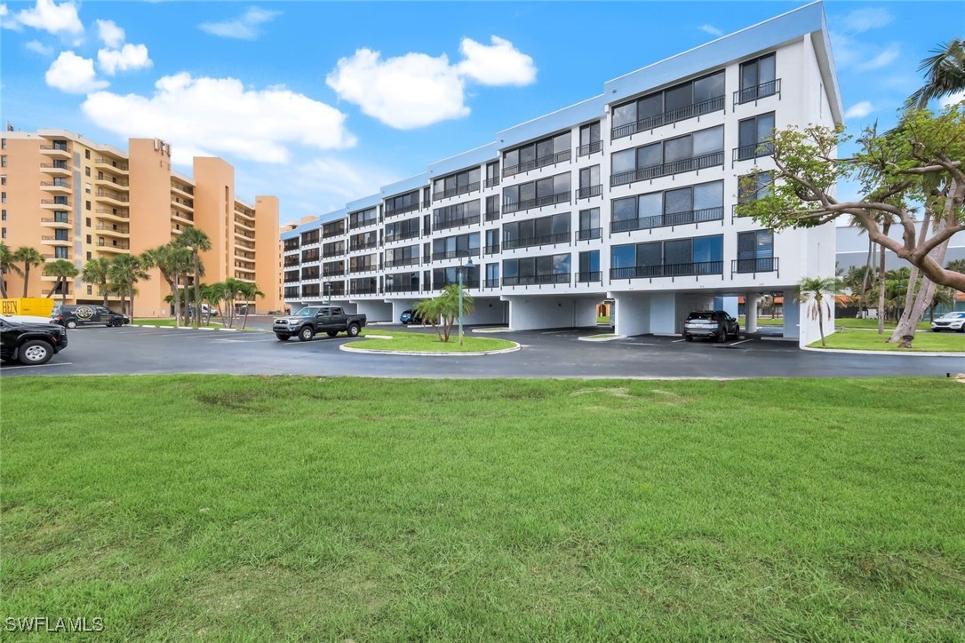 15010 Punta Rassa Road, Unit 108 Fort Myers, FL 33908 - Photo 3 of 30 a view of an apartment with a big yard and large trees
