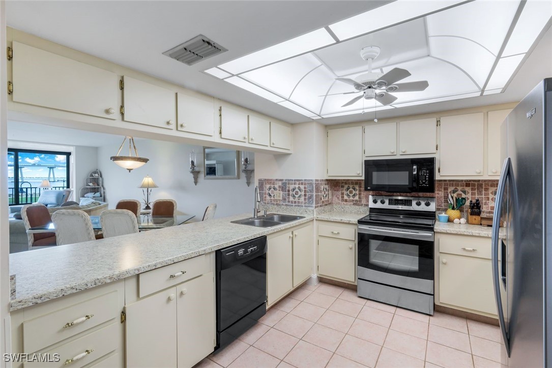 15010 Punta Rassa Road, Unit 108 Fort Myers, FL 33908 - Photo 8 of 30 a kitchen with granite countertop a sink stainless steel appliances and white cabinets