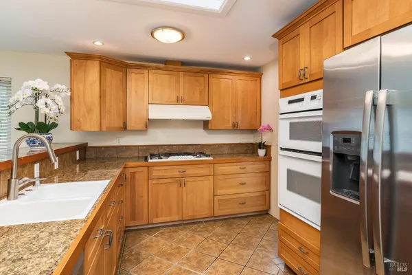 a kitchen with stainless steel appliances granite countertop a sink stove and cabinets