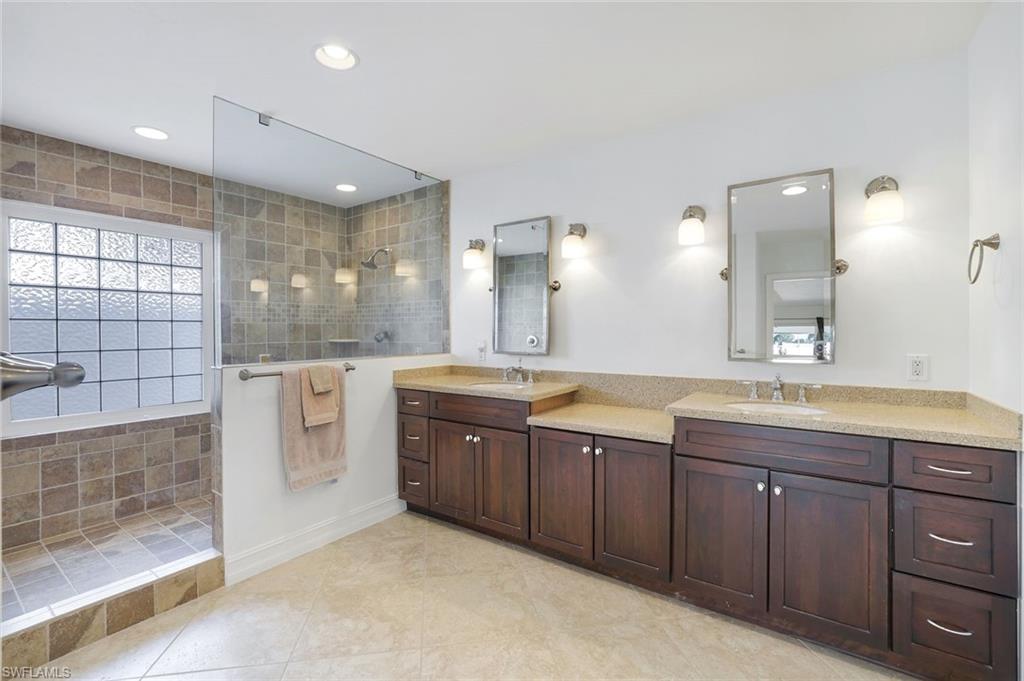 1819 Princess Court Naples, FL 34110 - Photo 14 of 25 a large bathroom with a double vanity sink and a mirror
