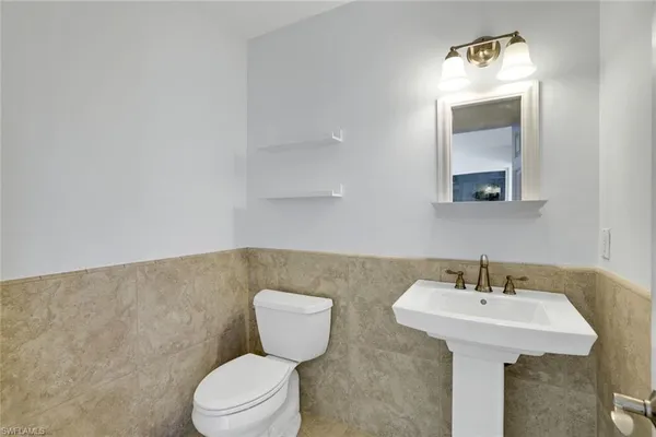 a bathroom with a toilet a sink and mirror