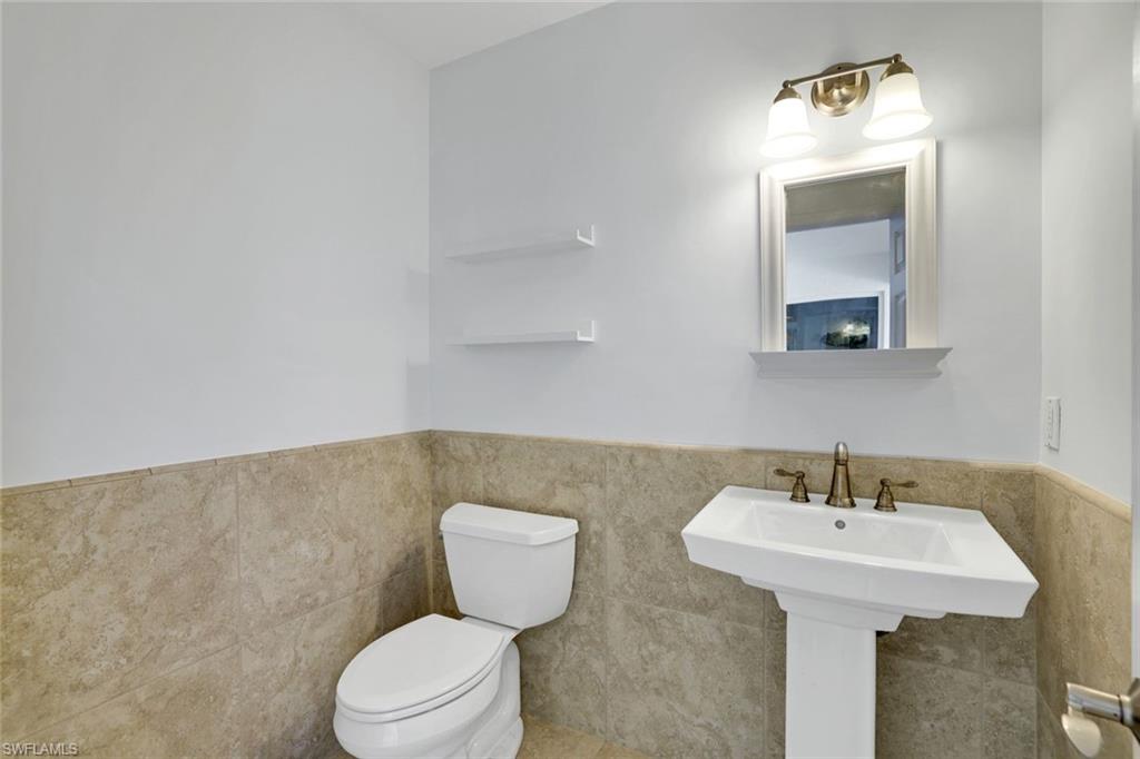 1819 Princess Court Naples, FL 34110 - Photo 19 of 25 a bathroom with a toilet a sink and mirror