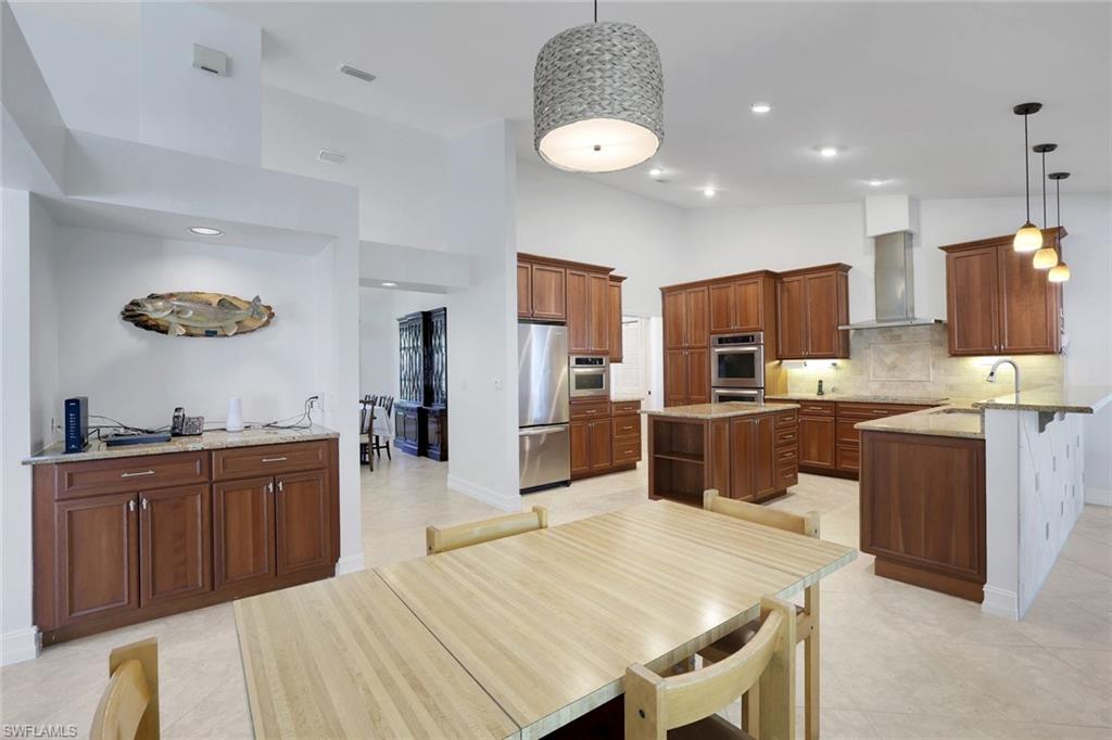 1819 Princess Court Naples, FL 34110 - Photo 2 of 25 a kitchen with stainless steel appliances kitchen island granite countertop a sink dishwasher stove top oven and refrigerator