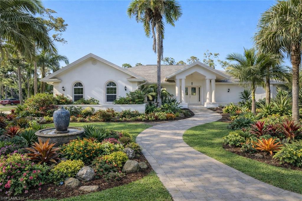 1819 Princess Court Naples, FL 34110 - Photo 21 of 25 a front view of a house with a garden and yard