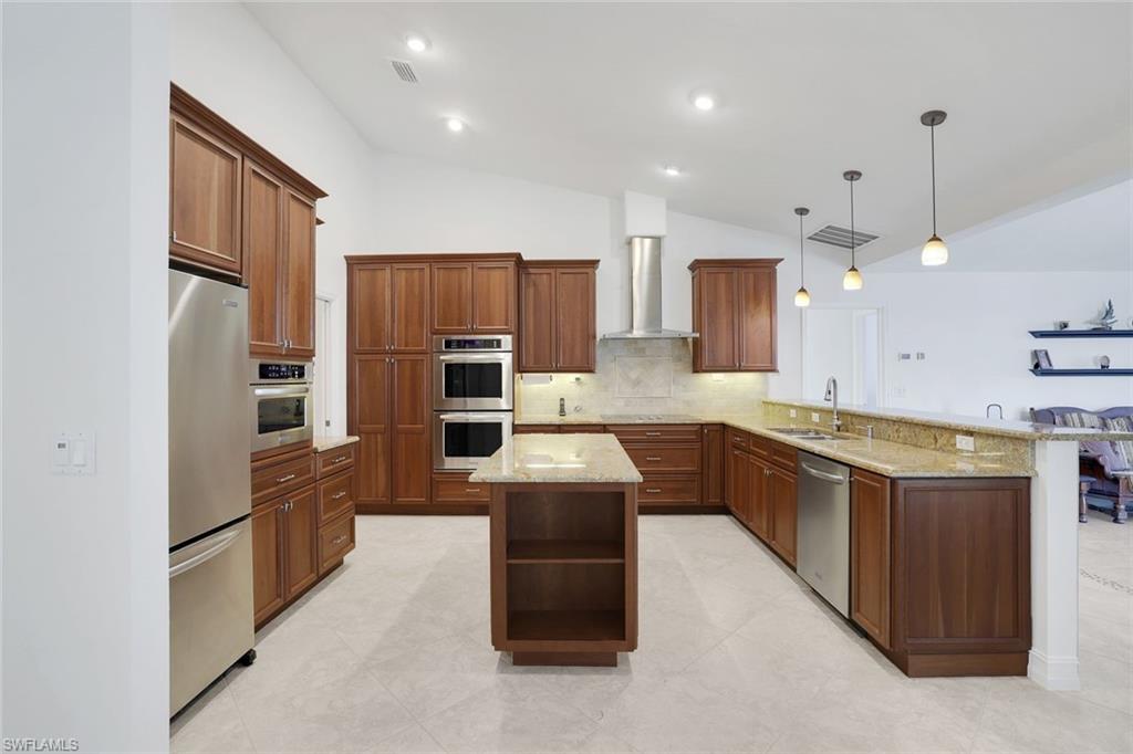 1819 Princess Court Naples, FL 34110 - Photo 3 of 25 a large kitchen with stainless steel appliances kitchen island granite countertop a refrigerator and a stove top oven