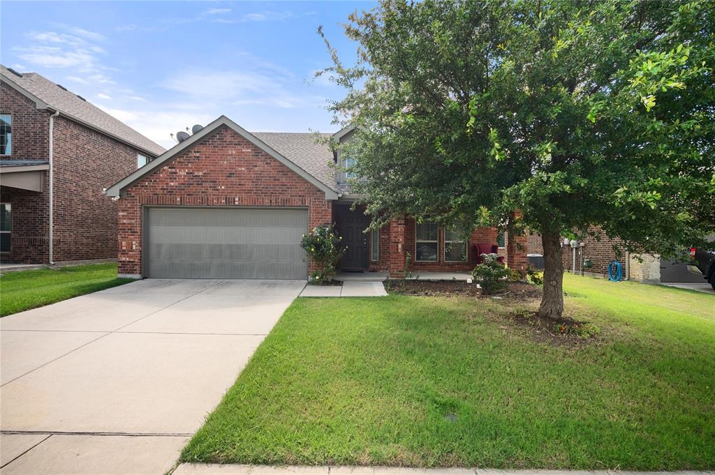520 Rustic Oak Lane McKinney, TX 75072 - Photo 2 of 30 Brick-front residence featuring a two-car garage, concrete driveway, front lawn, and mature tree