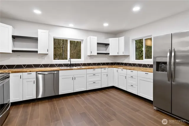 a kitchen with granite countertop white cabinets and stainless steel appliances
