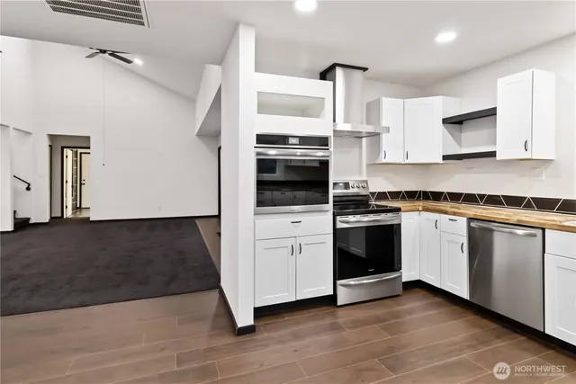 a kitchen with granite countertop white cabinets and white appliances
