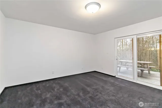a view of empty room with wooden floor and window