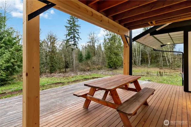a view of a patio with table and chairs under an umbrella with wooden floor