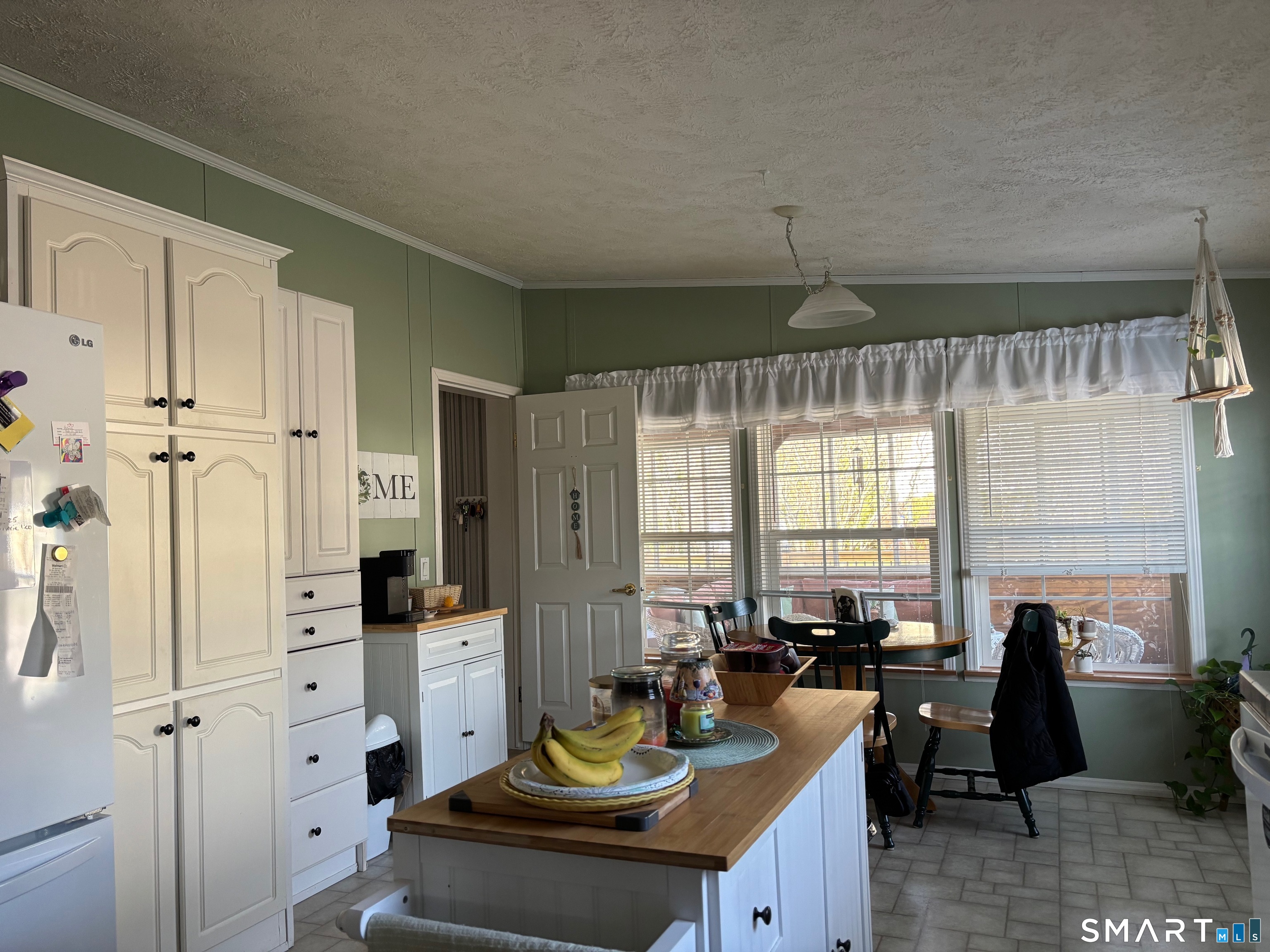 25 Kitty Lane Windham, CT 06256 - Photo 26 of 39 a kitchen with stainless steel appliances granite countertop a refrigerator a sink dishwasher a dining table and chairs with wooden floor