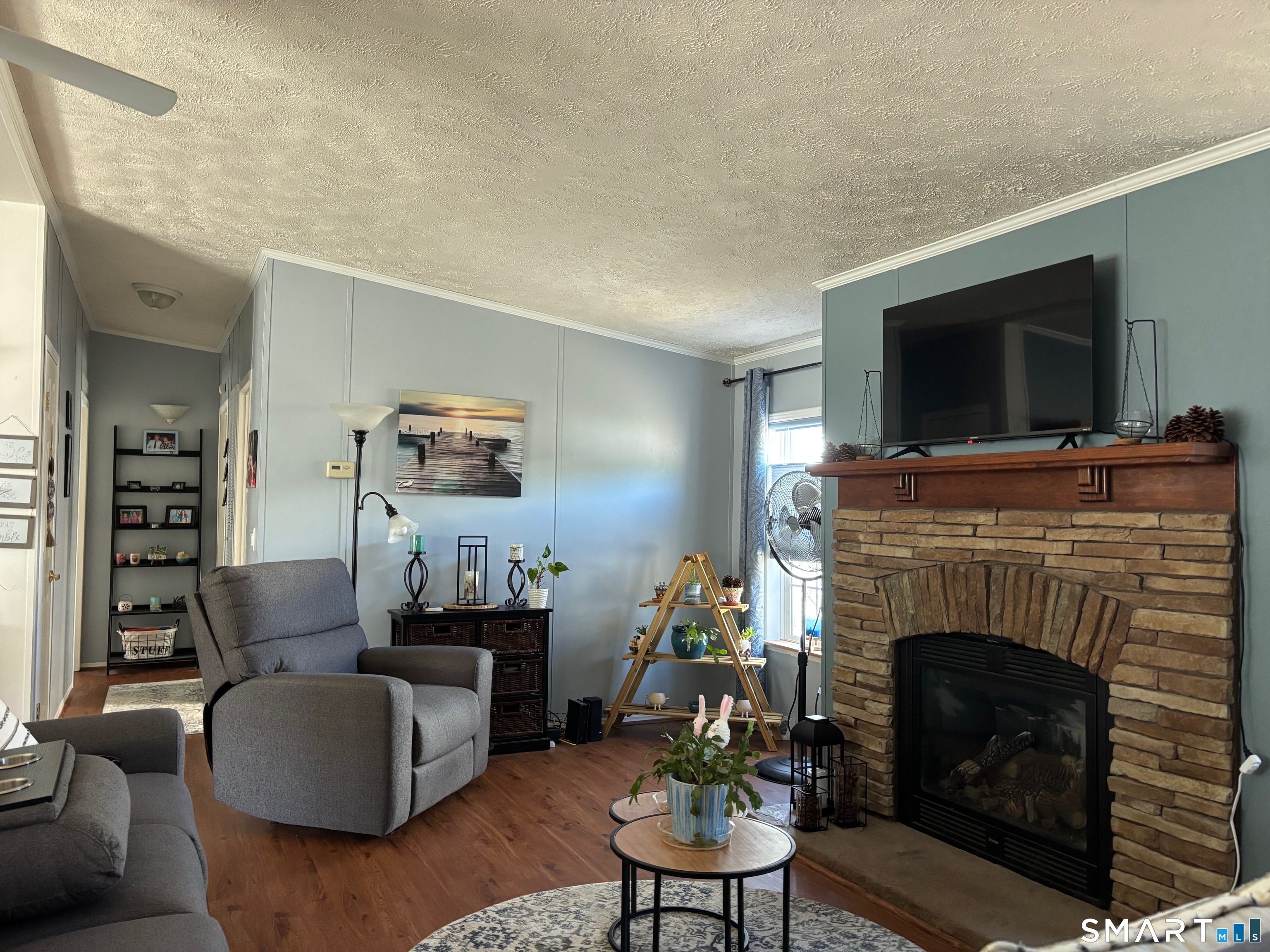 25 Kitty Lane Windham, CT 06256 - Photo 7 of 39 a living room with furniture a flat screen tv and a fireplace