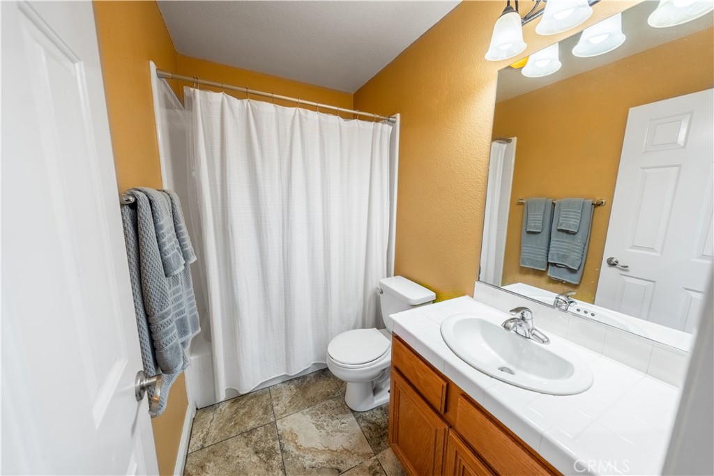 31465 Inverness Court Temecula, CA 92591 - Photo 12 of 71 a bathroom with a sink a toilet and shower curtain