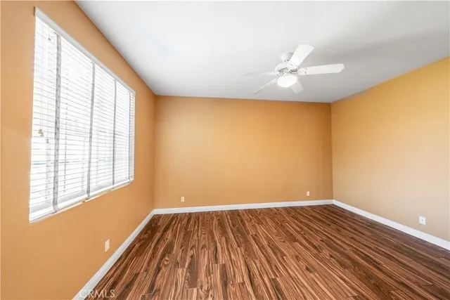 a view of wooden floor fire place and windows in an empty room