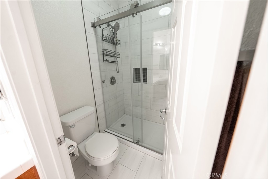 31465 Inverness Court Temecula, CA 92591 - Photo 30 of 71 a bathroom with a granite countertop toilet and a shower