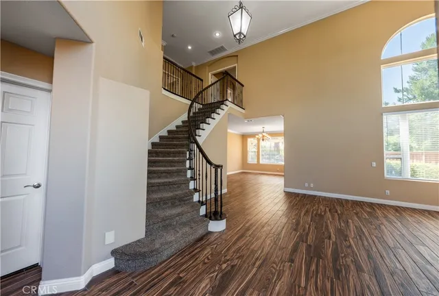 a view of a hallway with wooden floor and a bathroom