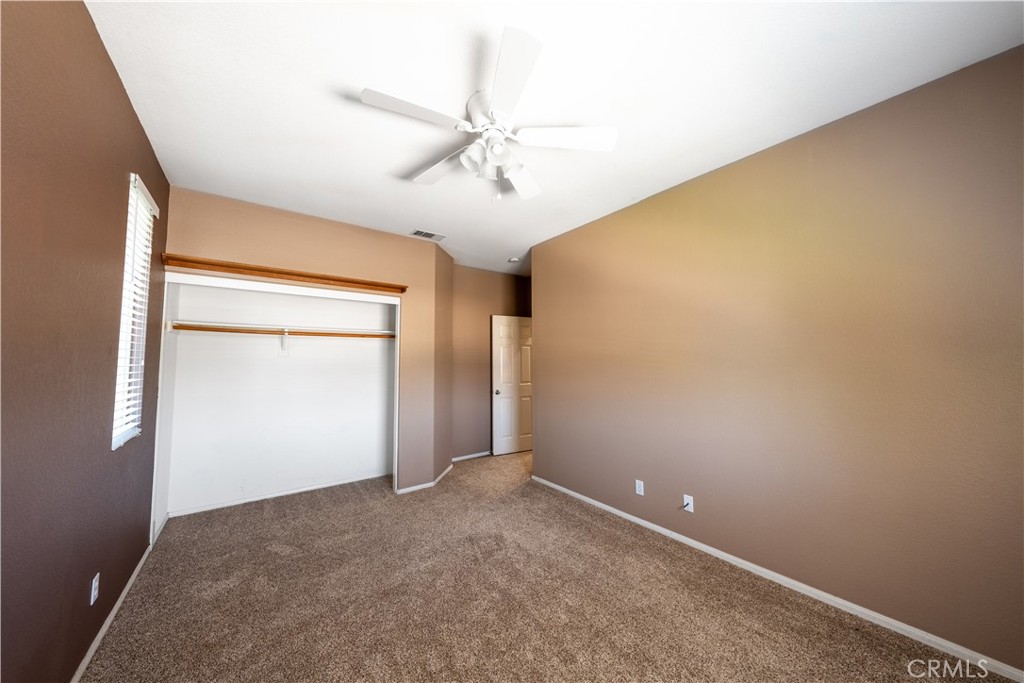 31465 Inverness Court Temecula, CA 92591 - Photo 36 of 71 an empty room with a chandelier fan and windows